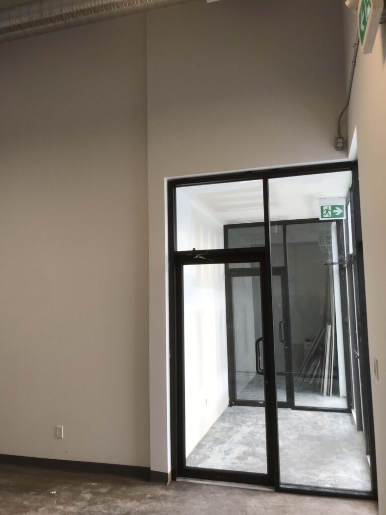 Completed drywall and glass door installation in a commercial space by Alberta Builder Services.