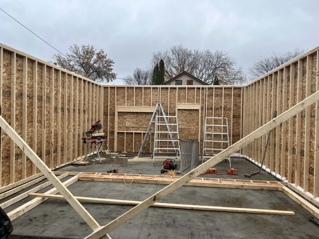 Interior view of a garage under construction with framed walls and tools on-site, built by Alberta Builder Services.