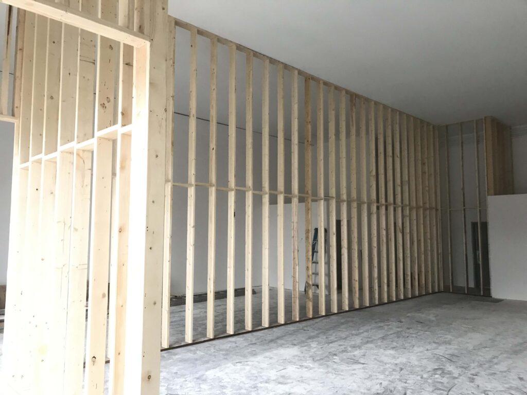 Wooden framing for a high-ceilinged commercial space by Alberta Builder Services, showcasing their expertise in custom construction solutions.