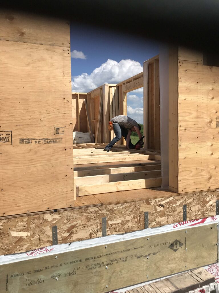 A construction worker frames a custom structure, showcasing Alberta Builder Services' craftsmanship in building custom solutions.