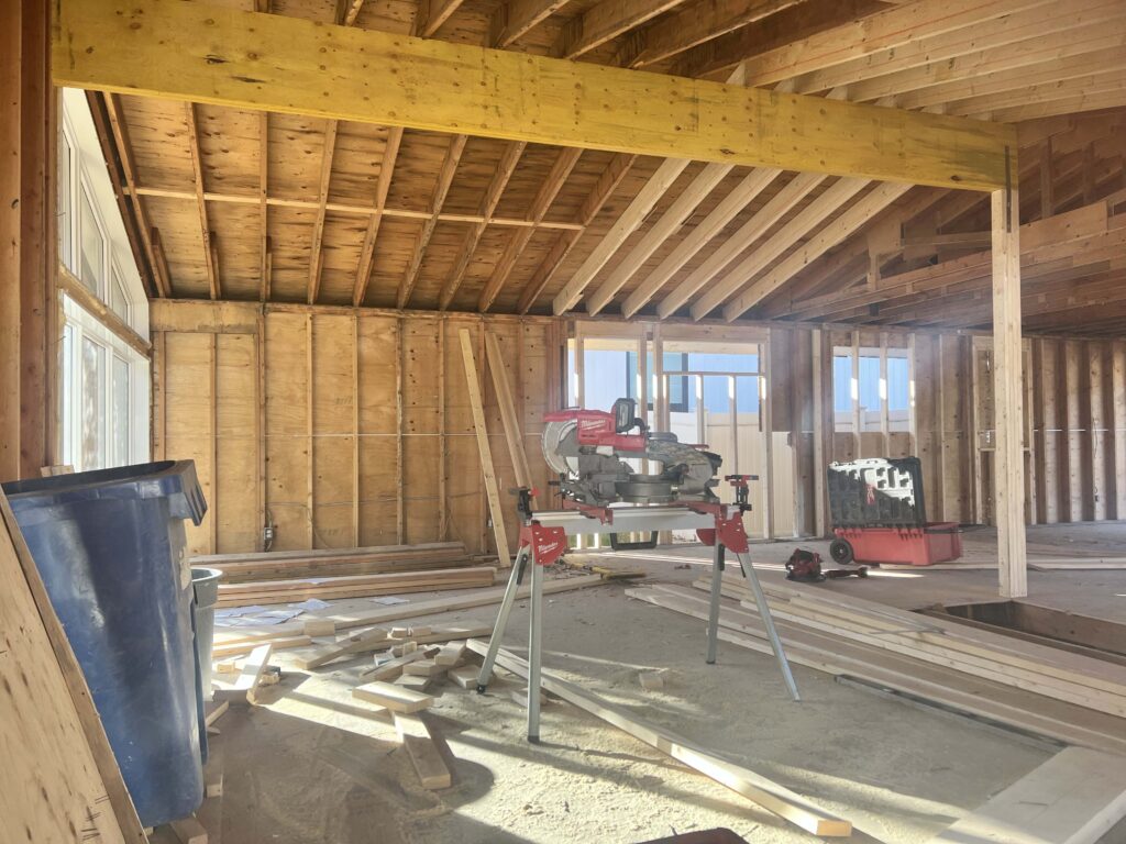 Interior view of a construction project showing exposed wooden framing and a saw, demonstrating Alberta Builder Services' expertise in custom solutions.