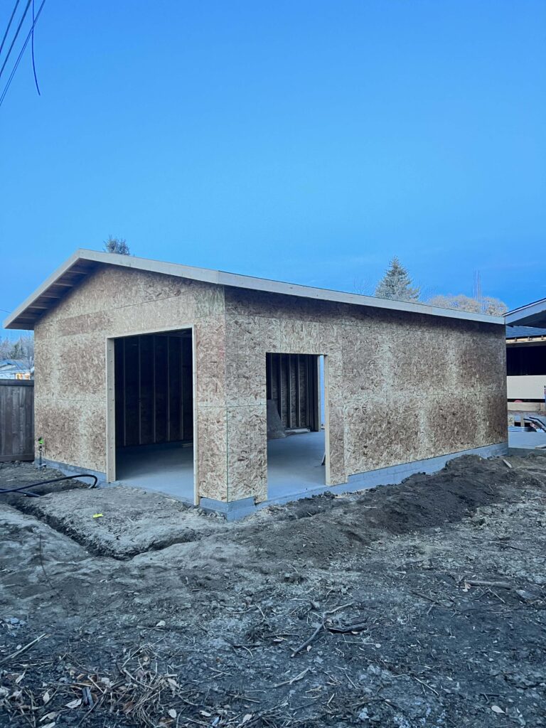 A newly framed garage with sheathed walls and roof, built by Alberta Builder Services.

