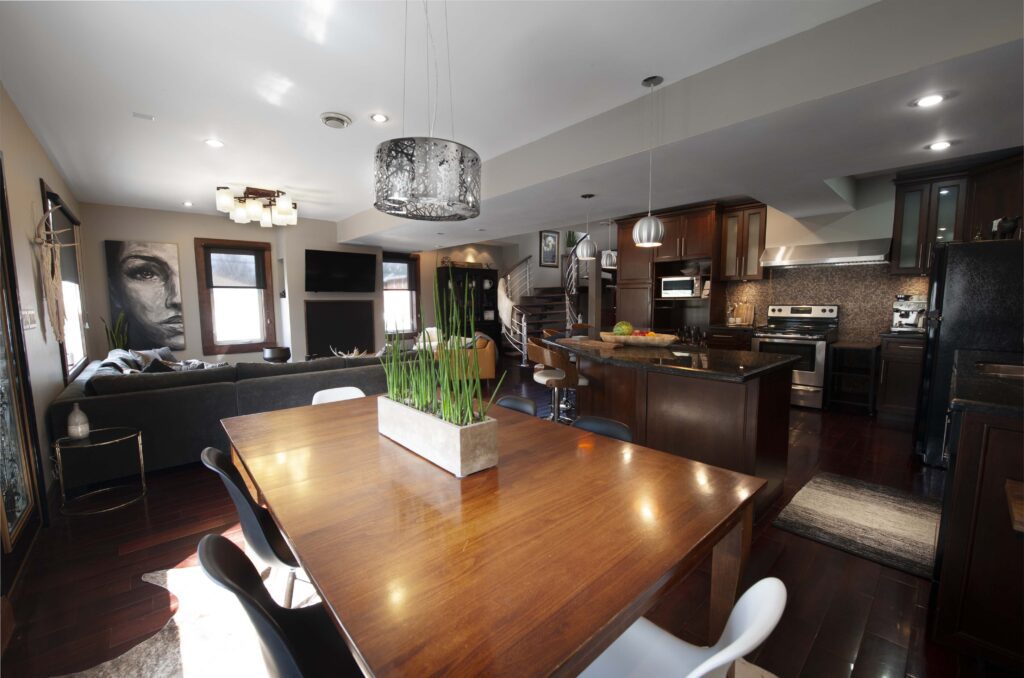 Open-concept dining and kitchen area with modern fixtures and wood accents, renovated by Alberta Builder Services.