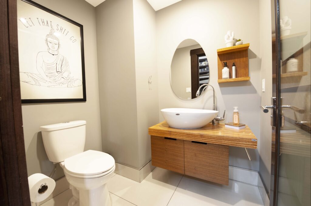 Modern half-bathroom with wood accents and a vessel sink, designed by Alberta Builder Services.