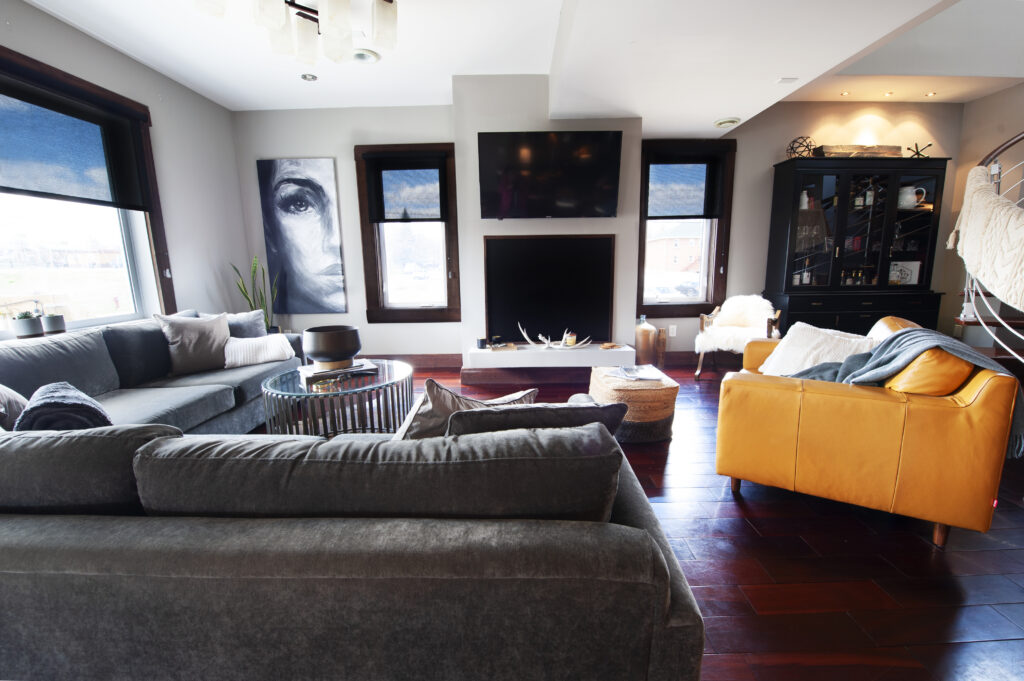 Modern living room with cozy furniture, hardwood floors, and a large wall-mounted TV.