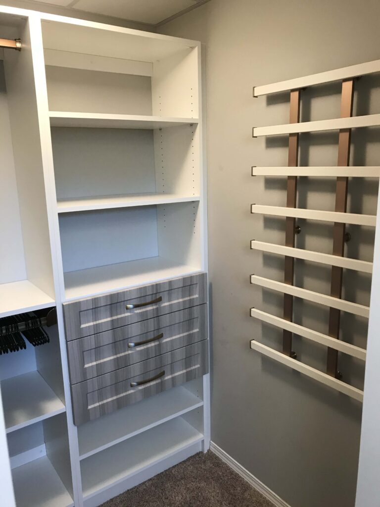 Custom-built closet storage solution featuring shelving, drawers, and a modern accessory rack.