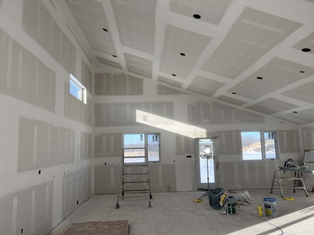 Spacious interior with completed drywall installation and taping by Alberta Builder Services.