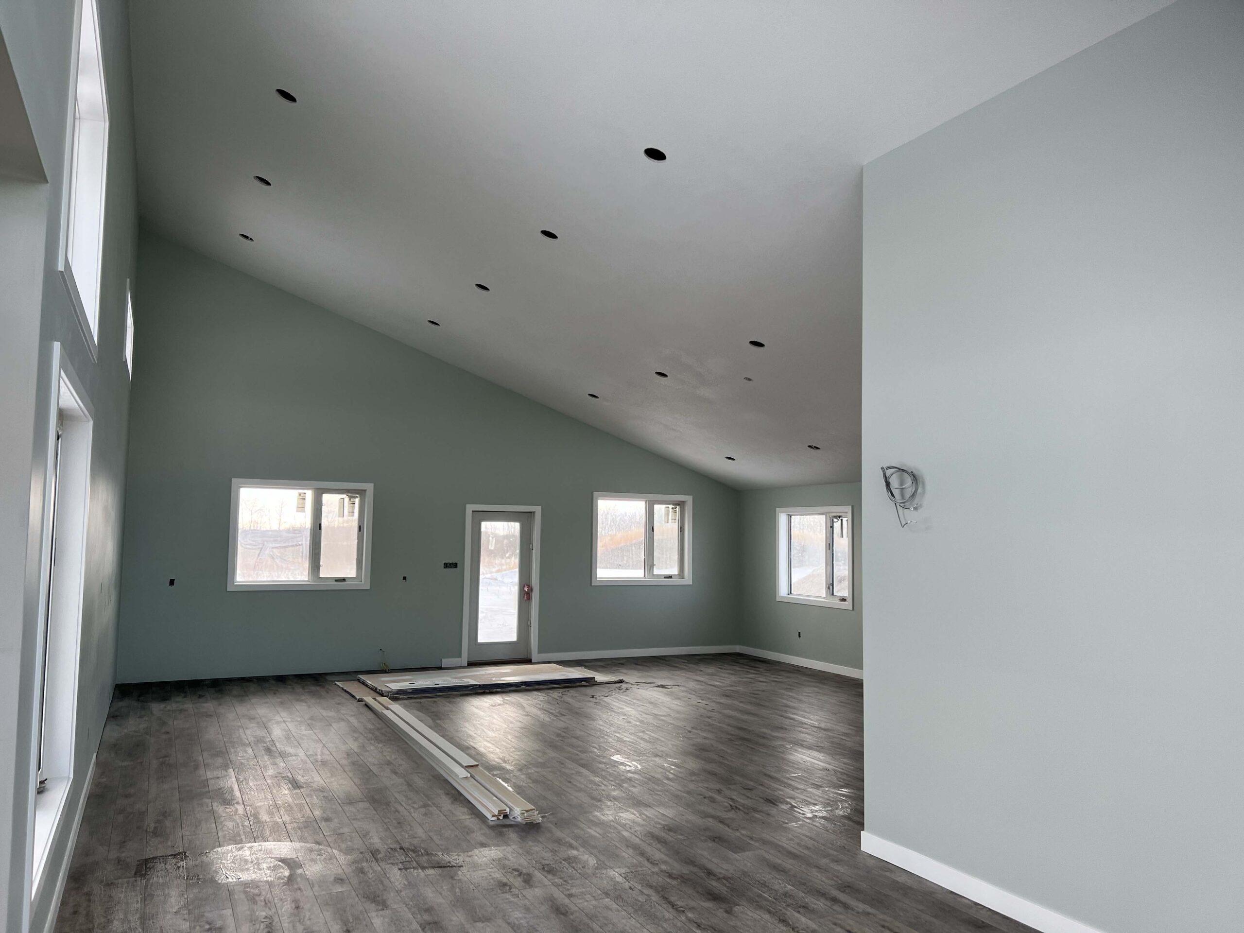 Completed residential interior with painted walls, installed flooring, and recessed lighting, showcasing Alberta Builder Services' custom construction expertise.