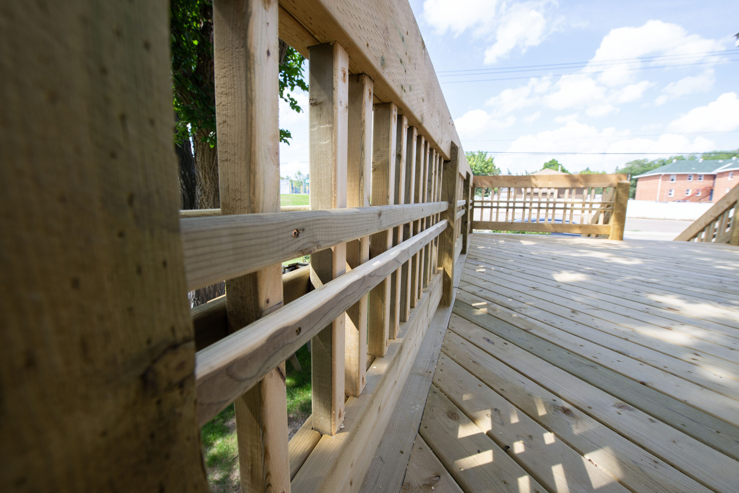 Close-up view of a custom wooden deck railing with intricate design, built by Alberta Builder Services.