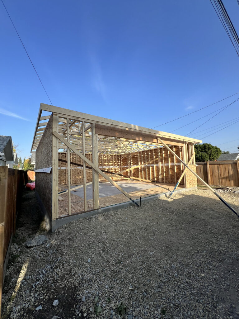 Detached garage framing and roof truss installation in progress in Edmonton, built by Alberta Builder Services Ltd.