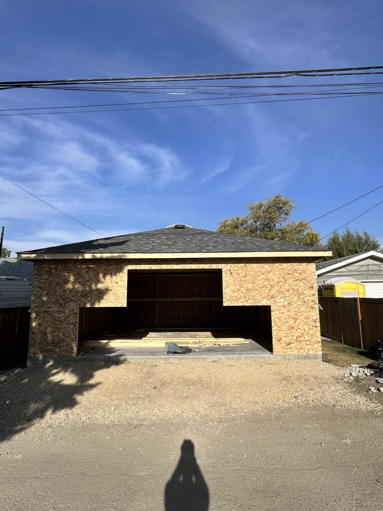 Detached garage under construction in Edmonton with roof sheathing installation underway by Alberta Builder Services Ltd.