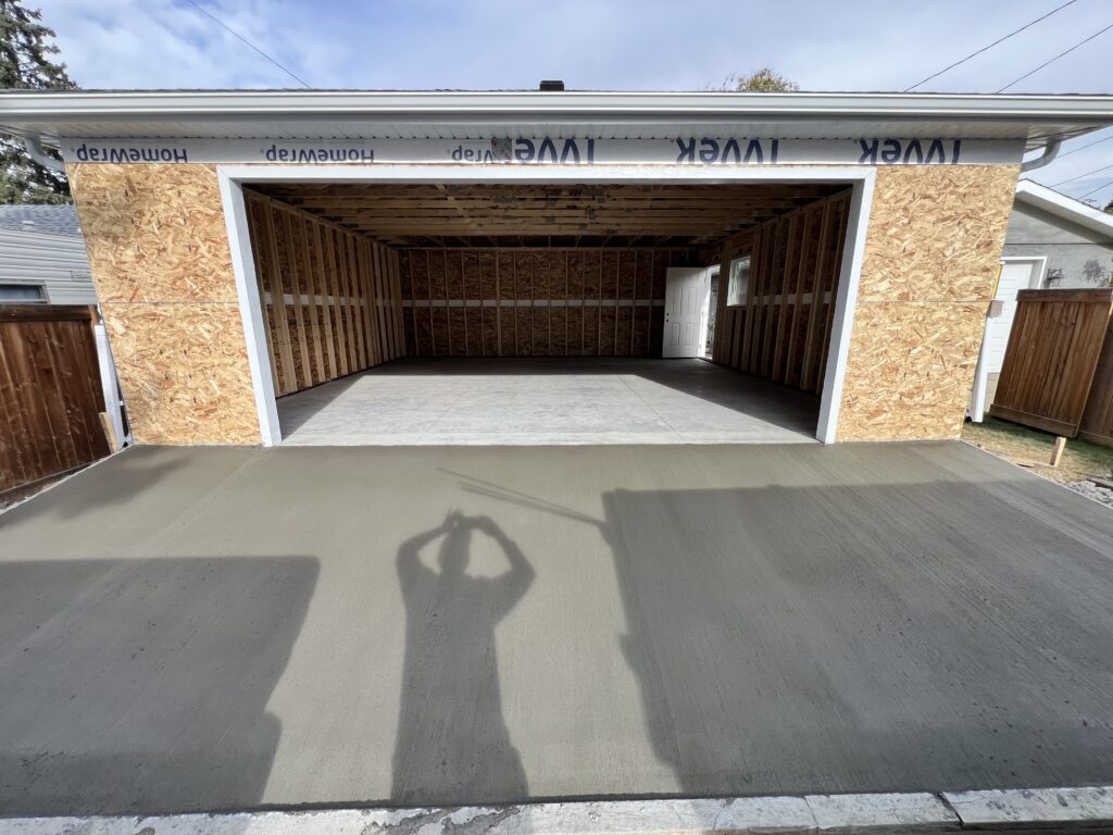 Freshly finished concrete apron and slab for a new detached garage in Edmonton, built by Alberta Builder Services Ltd.