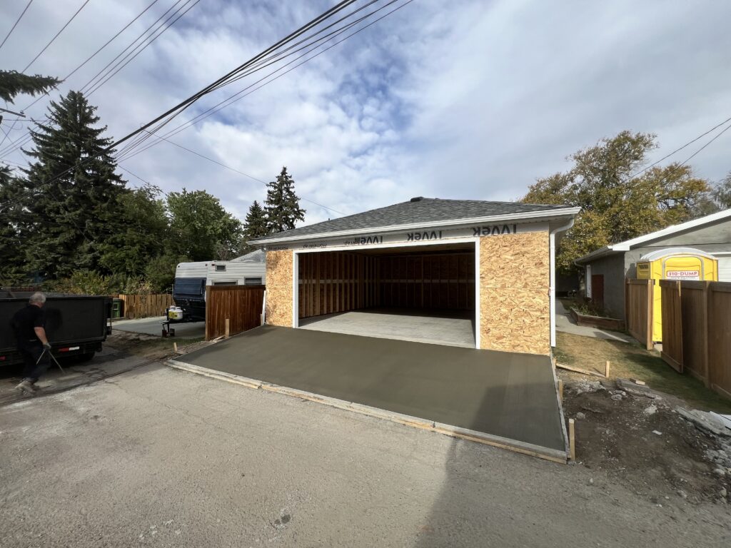 Detached garage in Edmonton with freshly poured concrete driveway apron built by Alberta Builder Services Ltd.