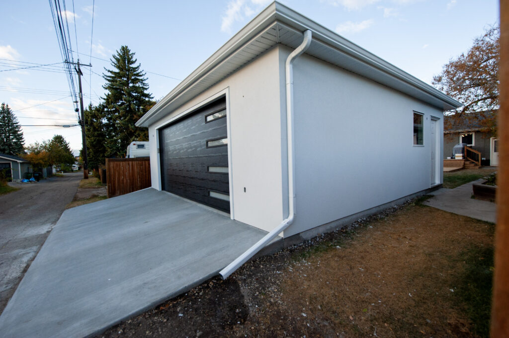 Detached garage exterior with fresh concrete driveway in Edmonton, Alberta
