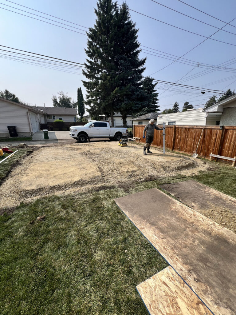 Garage site preparation in Edmonton showing compacted gravel base and grading work for a detached garage foundation by Alberta Builder Services