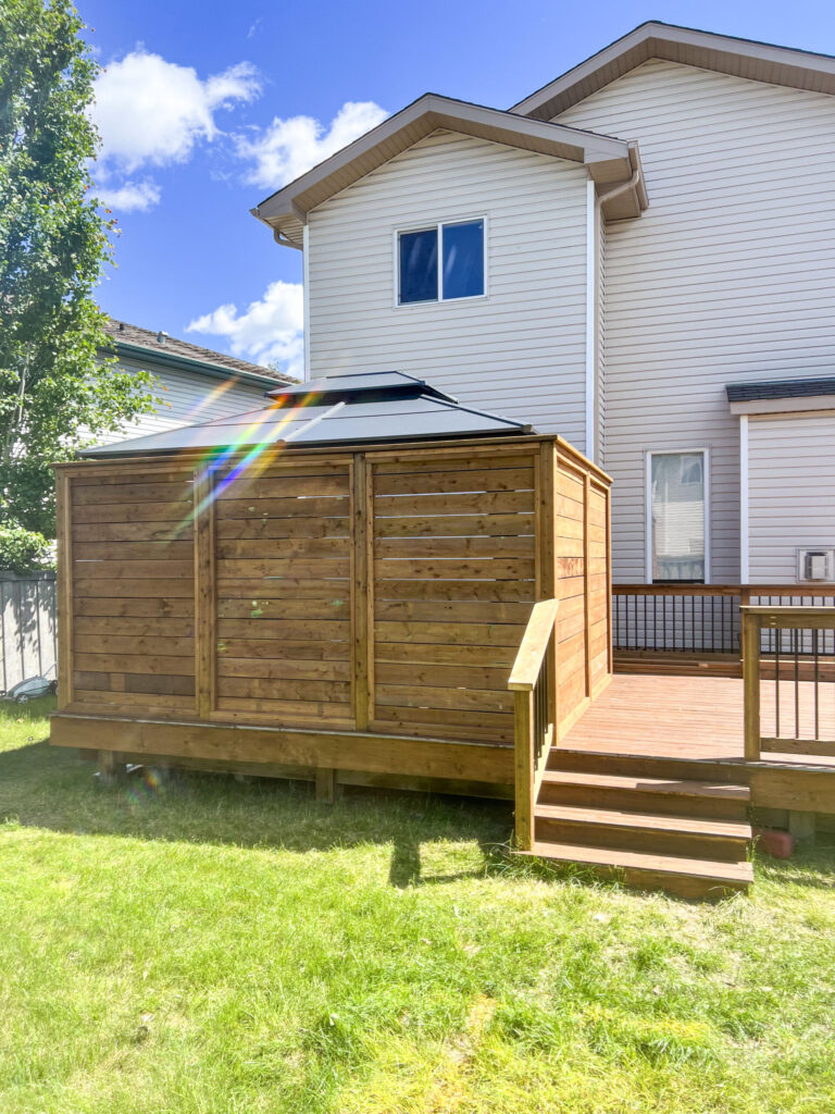 Completed raised deck with full privacy wall, gazebo roof, and wood entry stairs at a home in Edmonton, built by Alberta Builder Services Ltd.