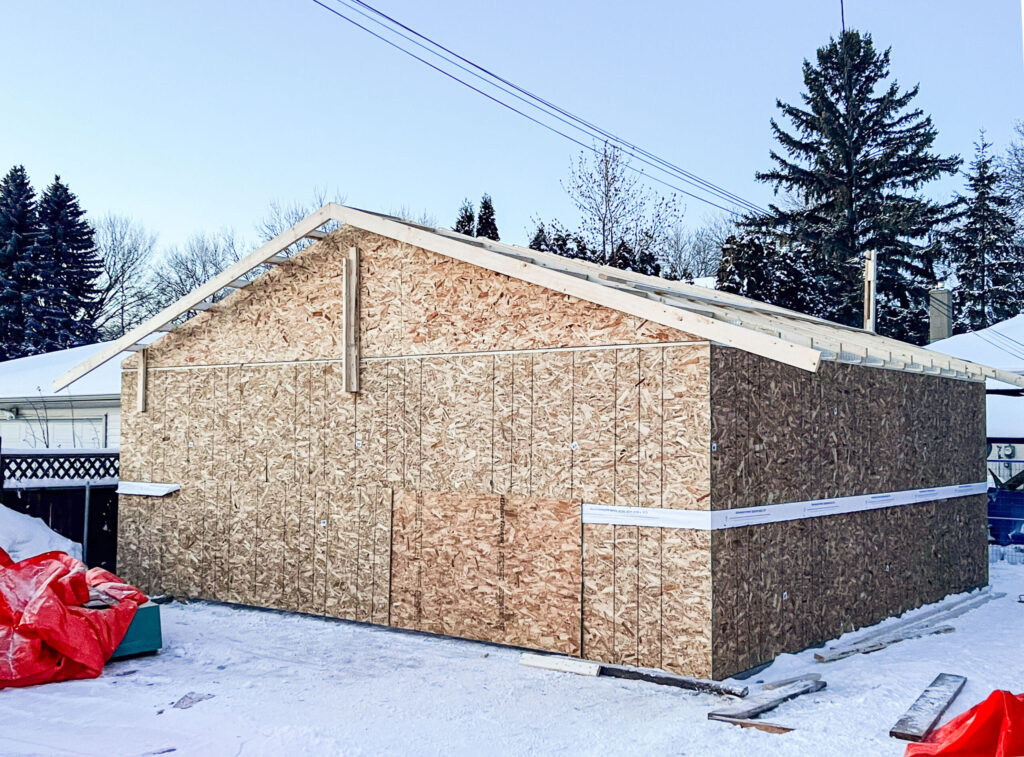 Detached garage exterior sheathing in progress in Edmonton showing OSB wall sheathing and roof framing by Alberta Builder Services