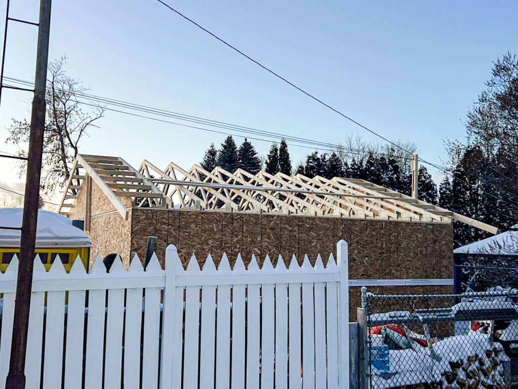 Detached garage roof truss installation in Edmonton showing engineered trusses set over exterior sheathing by Alberta Builder Services