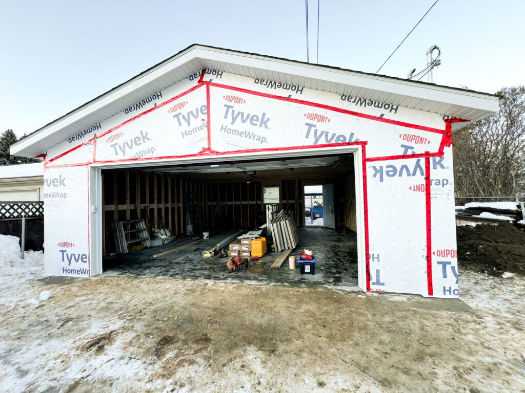 Detached garage in Edmonton wrapped with Tyvek housewrap and sealed openings, preparing for siding and exterior finishes by Alberta Builder Services