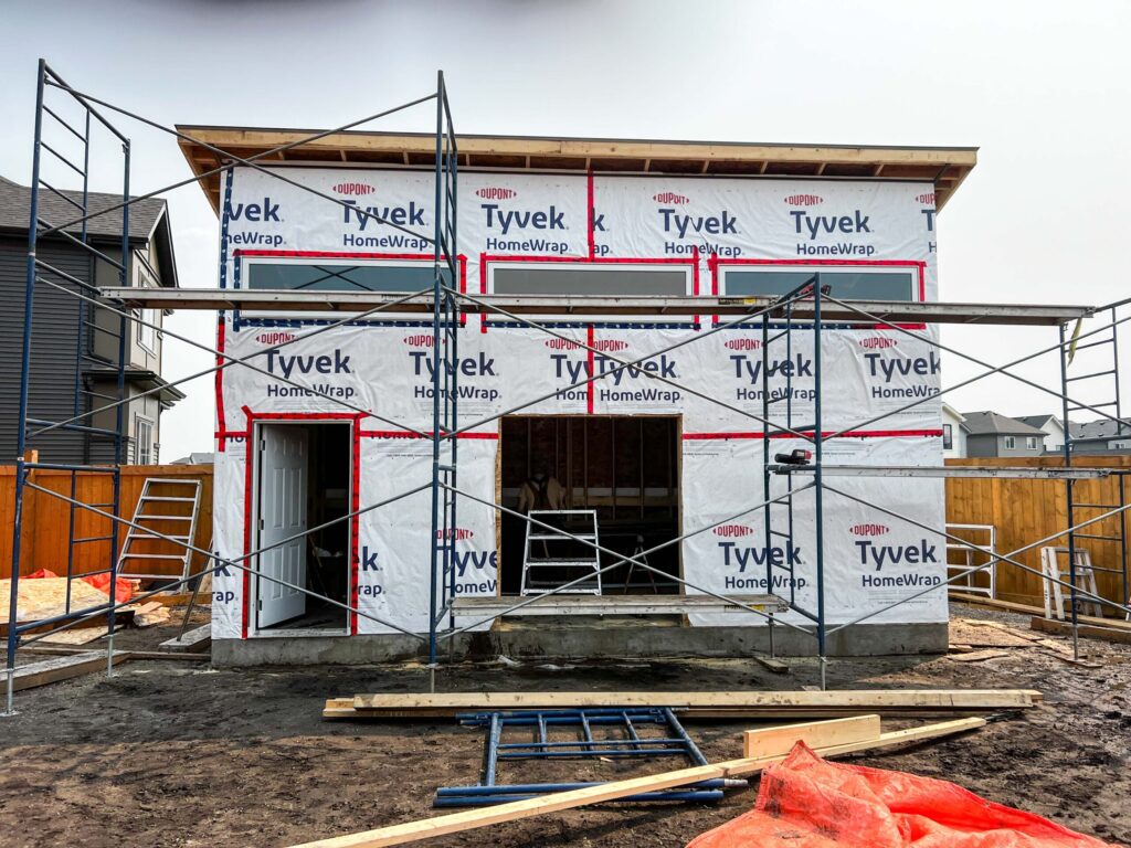 Front elevation of a custom oversized detached backyard shed during weather barrier installation in the Greater Edmonton area by Alberta Builder Services Ltd.