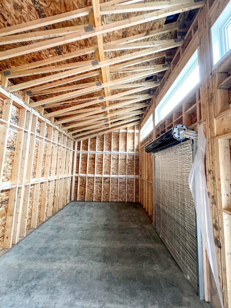 Long interior view of a custom oversized detached backyard shed with engineered vaulted roof framing in the Greater Edmonton area by Alberta Builder Services Ltd.