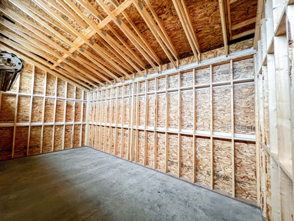 Interior framing of a custom oversized detached backyard shed with vaulted ceiling and open storage space in the Greater Edmonton area by Alberta Builder Services Ltd.